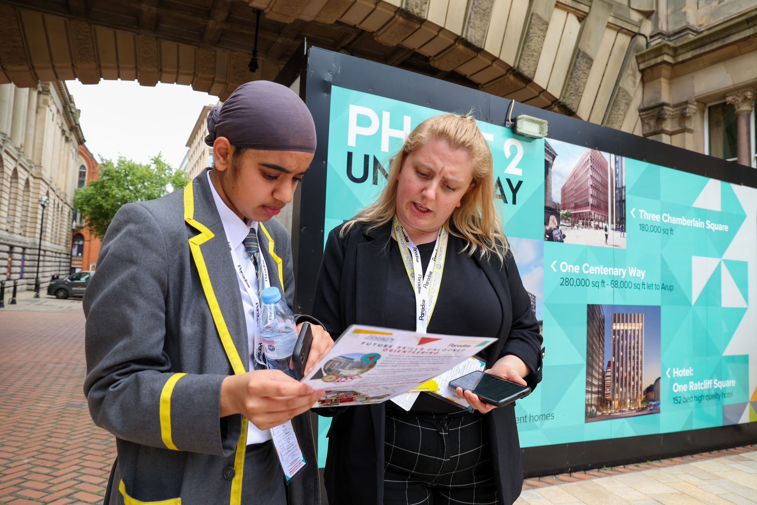 Student and teacher standing outside at Paradise Birmingham, looking at a worksheet.